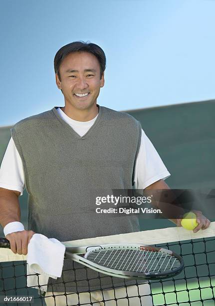 portrait of a man holding a tennis racket on a tennis court - tennis court stock pictures, royalty-free photos & images