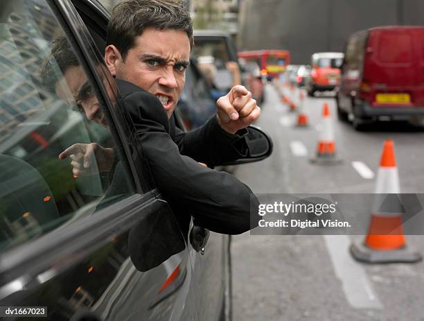 angry man looking out his car window pointing - road rage stock pictures, royalty-free photos & images