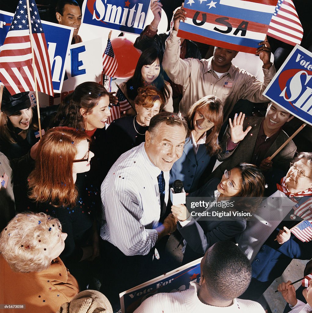 Politician Being Interviewed in the Middle of a Large Crowd During a Political Rally