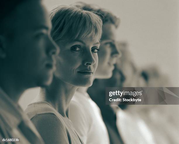 businesswoman in lineup with younger men - lineup fotografías e imágenes de stock