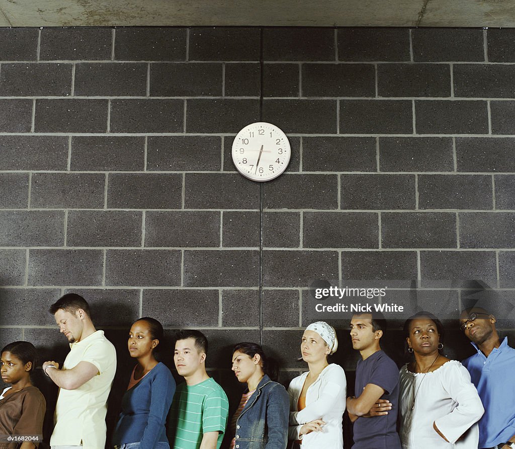 Group of Students Queuing Against a Brick Wall