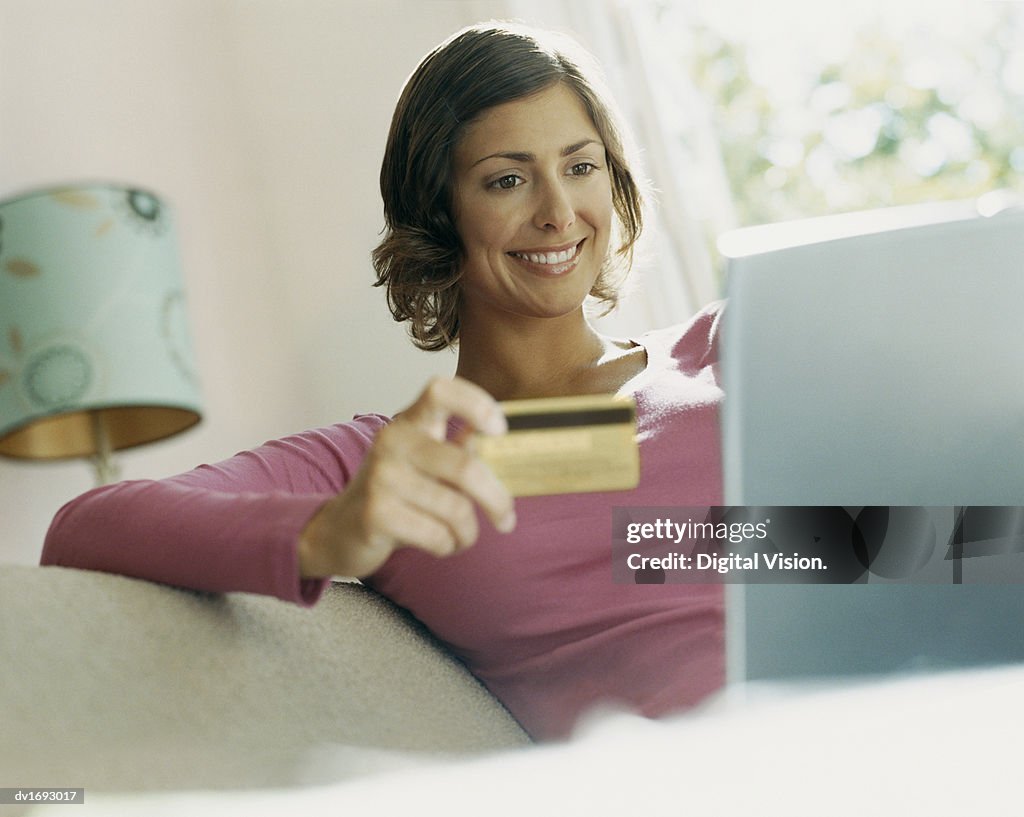 Woman Using Her Bank Card Online With a Laptop