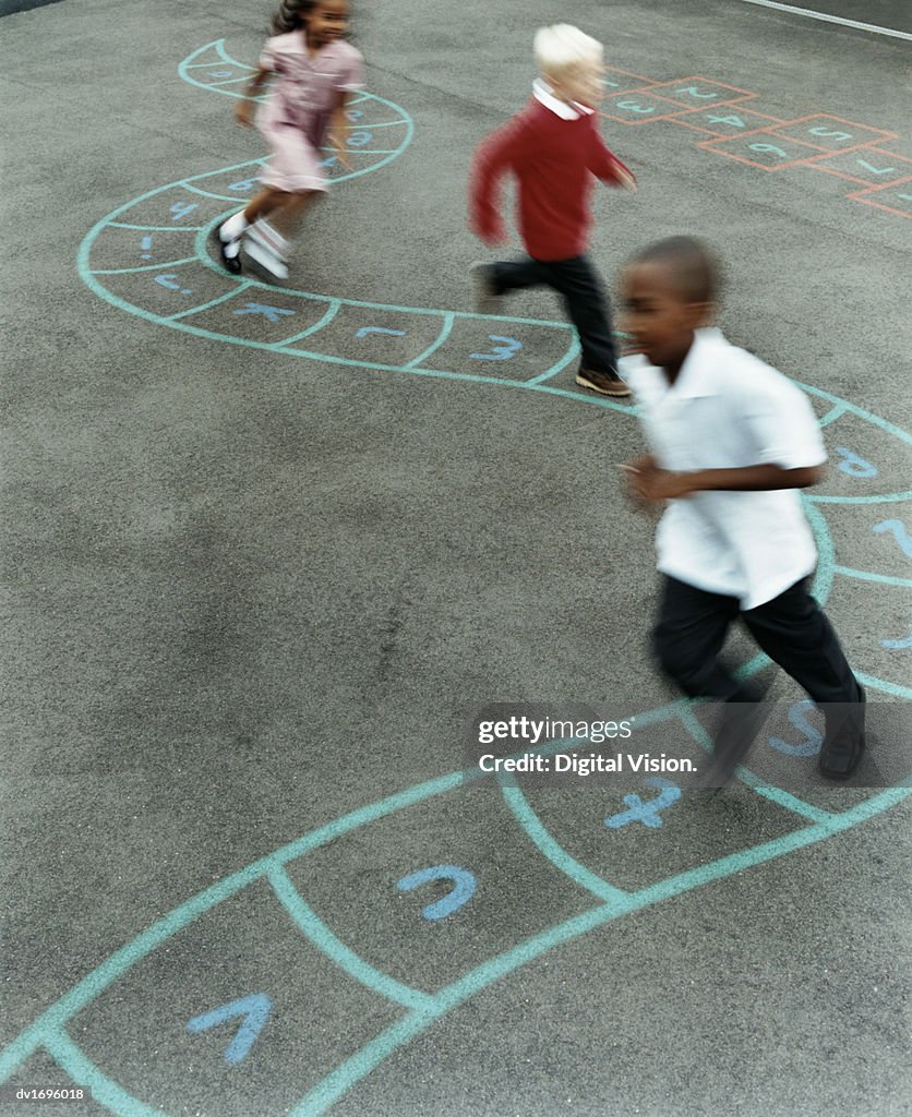 Primary School Children Chasing Each Other in a School Playground