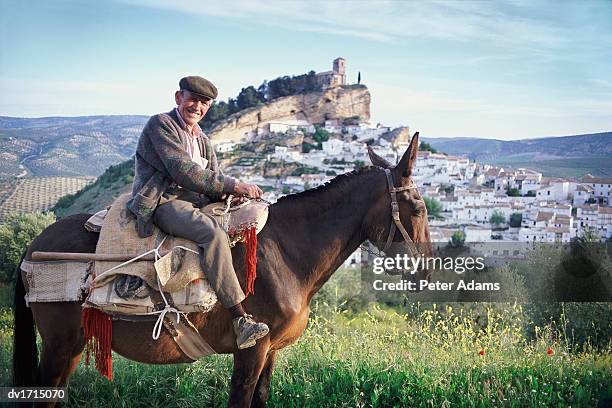 senior man sits on a horse, smiling at the camera, montefrio, andalucia, spain - andalucia stock pictures, royalty-free photos & images