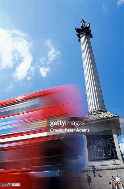 double decker bus driving past nelson's column on trafalgar square, tourists sitting on steps, london, uk - peter nelson imagens e fotografias de stock