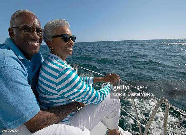 senior couple sat together on a yacht - sailing couple stock pictures, royalty-free photos & images