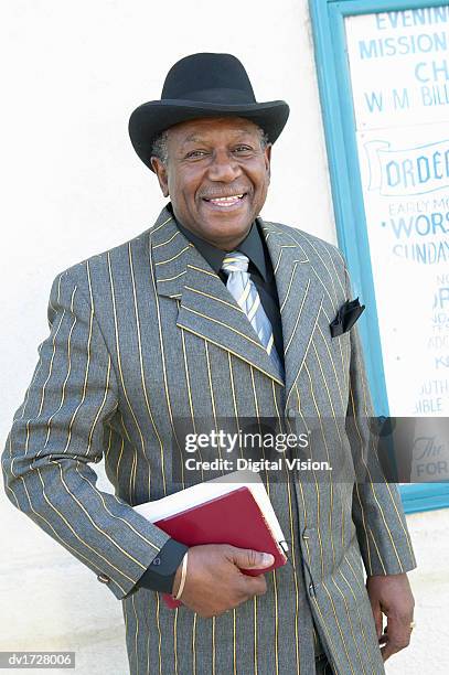 portrait of a well dressed senior man in a pinstripe suit, holding a bible - black lapel stock pictures, royalty-free photos & images
