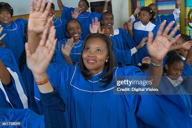 congregation of gospel singers with raised hands singing in a church service - gospel music stock-fotos und bilder