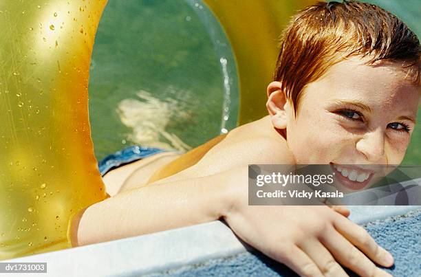 young boy in a swimming pool with a rubber ring - rubber ring - fotografias e filmes do acervo