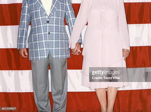 low section shot of a man and woman holding hands in front of the stars and stripes - lionsgate uk screening of film stars dont die in liverpool after party stockfoto's en -beelden