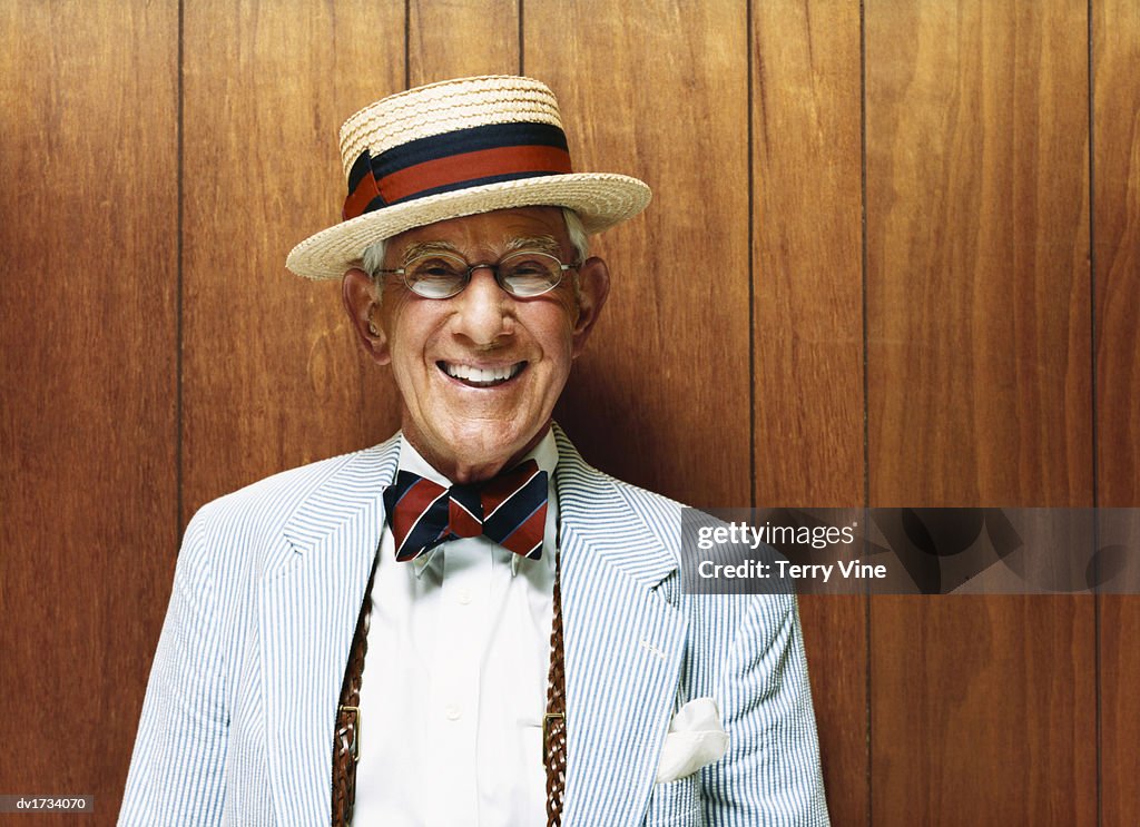 Portrait of a Smiling Senior Wearing a Striped Suit and a Straw Hat