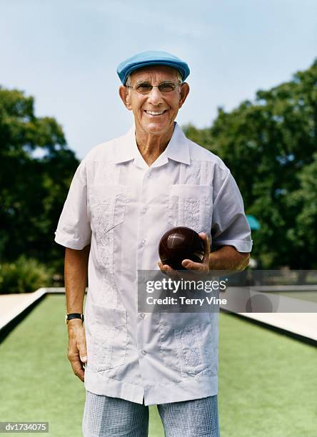 smiling senior man holding a bowling ball - senior men bowling stock pictures, royalty-free photos & images