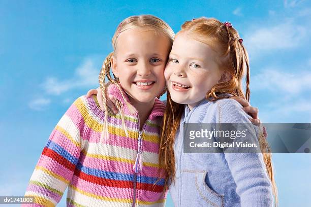 portrait of two young girls with their arms around each other - wange an wange stock-fotos und bilder