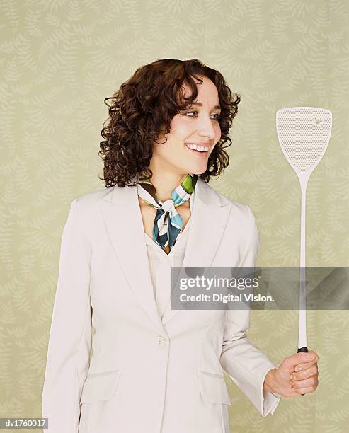 woman holding a fly swatter with a dead fly on it - swat stock pictures, royalty-free photos & images
