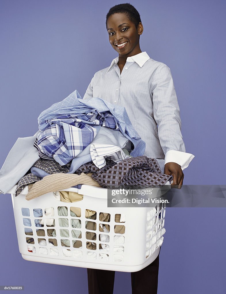 Woman Stands Holding a Washing Basket Full of Laundry