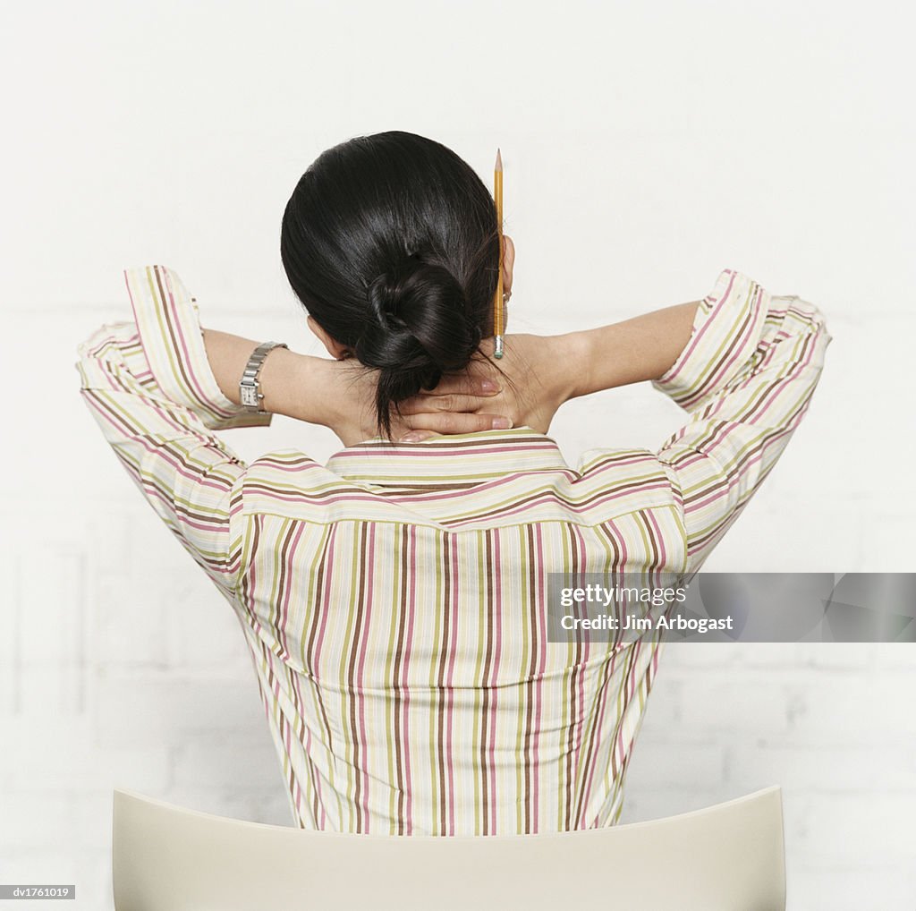 Rear View of a Woman with Her Hands on Her Neck