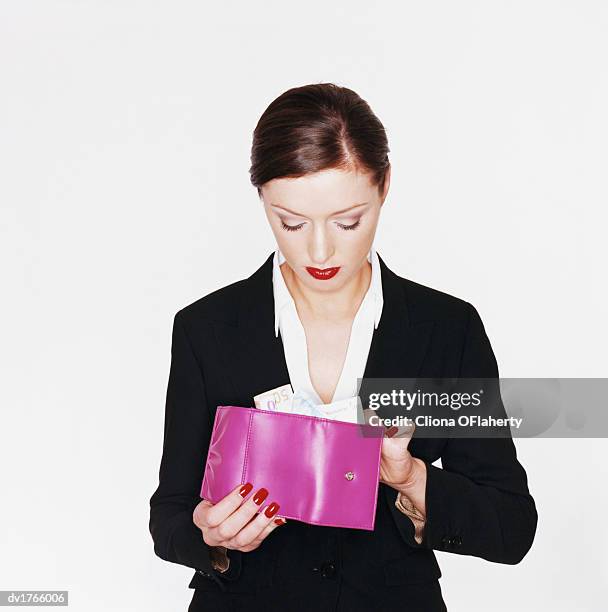 businesswoman holding a pink wallet with money - 50 pound notes stock pictures, royalty-free photos & images