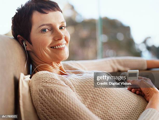 woman lies listening to music on an mp3 player - mp stock pictures, royalty-free photos & images