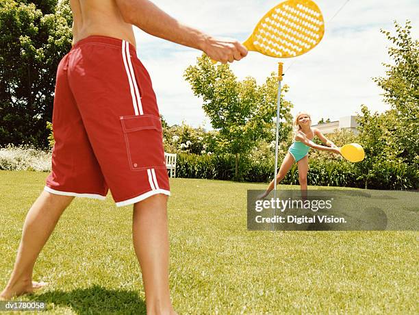 father and a daughter hold rackets and playing paddle ball together - paddle ball stock pictures, royalty-free photos & images