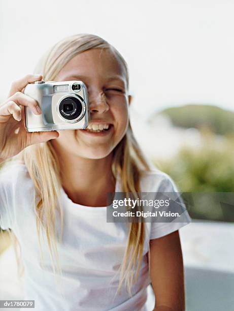 portrait of a young girl taking a picture with a digital camera - camera picture ストックフォトと画像