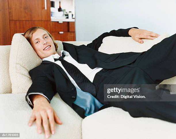 young bachelor lying on a sofa - the bachelor imagens e fotografias de stock