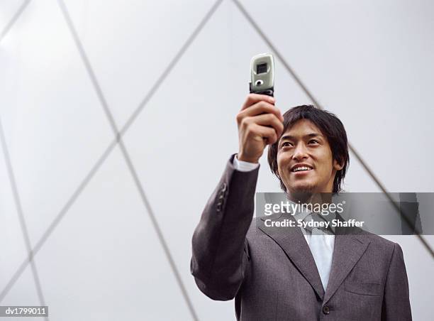 businessman photographing himself with a video phone - video wall fotografías e imágenes de stock