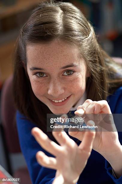 smiling school girl stretching a rubber band - rubber band stockfoto's en -beelden