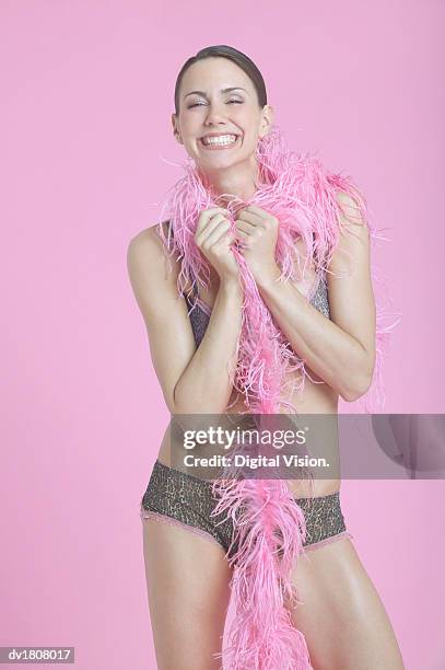 smiling woman wearing underwear holding a pink feather boa - feather boa 個照片及圖片檔