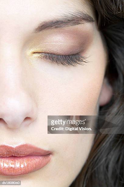 young woman with her eyes closed wearing golden make up - beautiful woman and eyeshadow stock pictures, royalty-free photos & images
