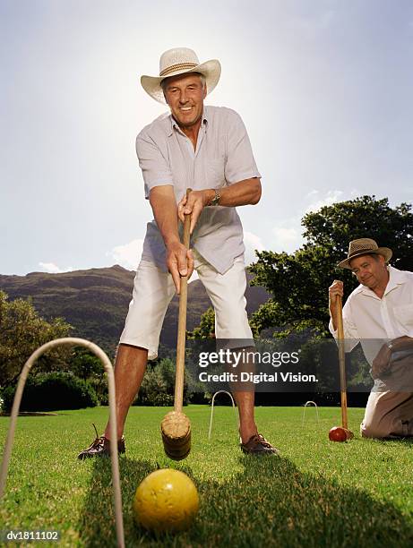 two senior men playing a game of croquet - croquet fotografías e imágenes de stock