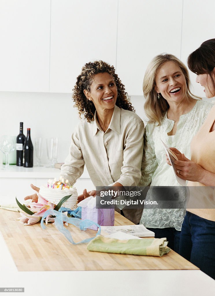 Three Women In A Kitchen Preparing A Birthday Cake And Birthday