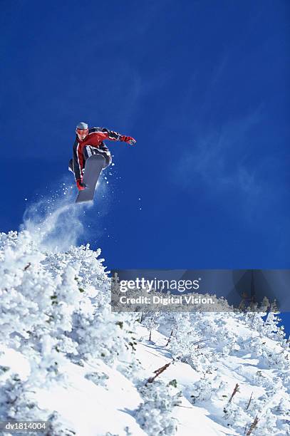 low angle view of a man freestyle snowboarding, mid air - freestyle snowboarding imagens e fotografias de stock