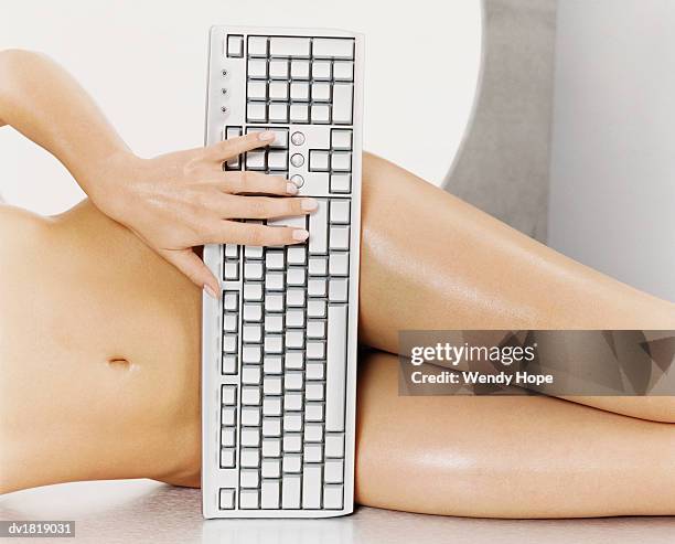 low section shot of a naked woman covering herself with a keyboard - hope imagens e fotografias de stock