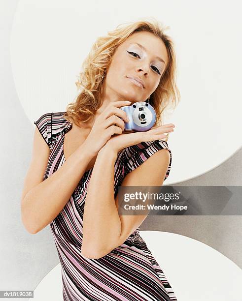 portrait of a woman wearing a striped dress posing with a camera - hope imagens e fotografias de stock