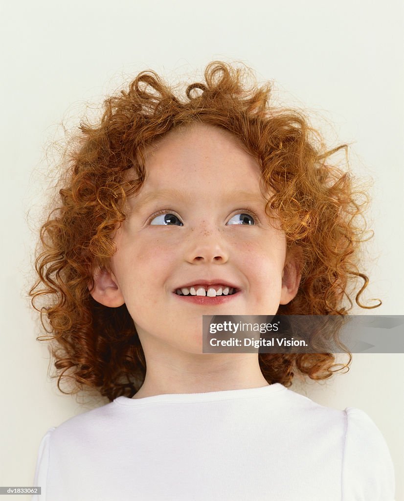 Portrait of a Young Girl With Curly, Red Hair, Looking Up