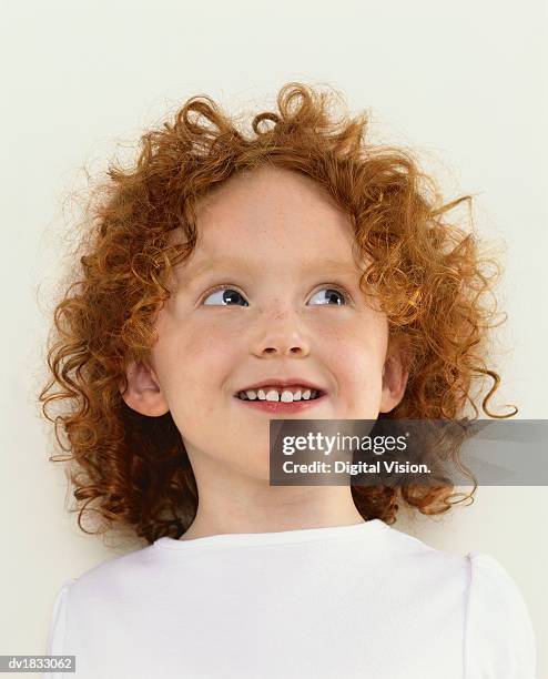 portrait of a young girl with curly, red hair, looking up - endast en flicka bildbanksfoton och bilder