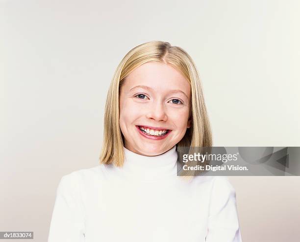 studio portrait of a young girl in a white polo-neck jumper smiling - polo neck stock-fotos und bilder