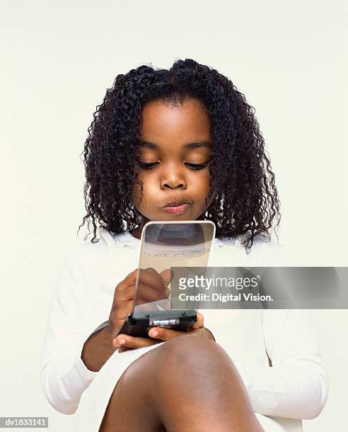 portrait of a young girl sitting down using a handheld pc - female puckered lips stockfoto's en -beelden