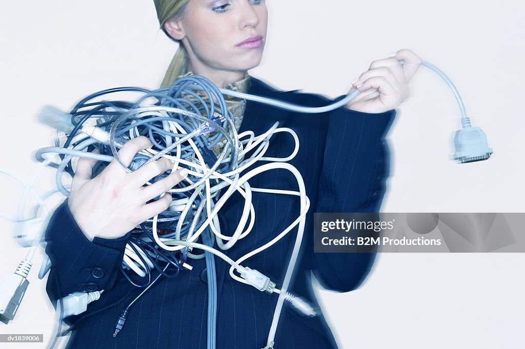 Businesswoman Holding Tangled Computer Cables