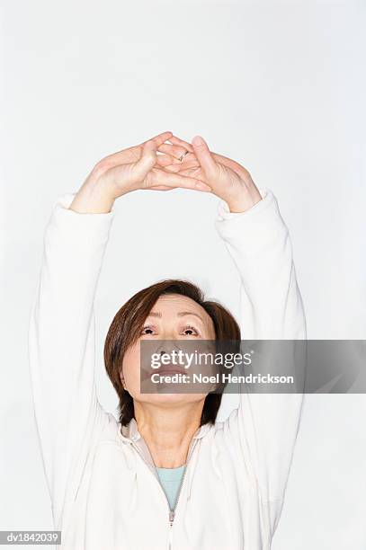 woman wearing a white tracksuit top practicing yoga - tracksuit jacket stock pictures, royalty-free photos & images