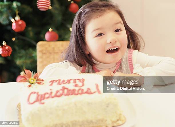 girl sits leaning on a table with a christmas cake - long term vision bildbanksfoton och bilder