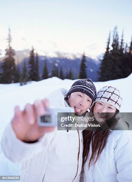 couple photographing themselves on a winter holiday - voyage15 photos et images de collection