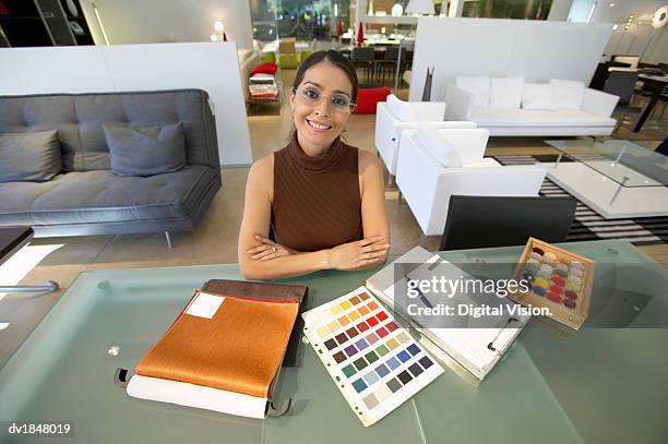 interior design shop assistant sitting behind a table in a design shop - clipboard and glasses stock pictures, royalty-free photos & images