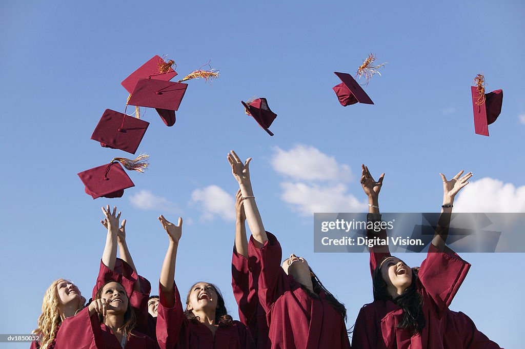 Line of Female Students Throwing Their Mortar Boards in the Air at Graduation