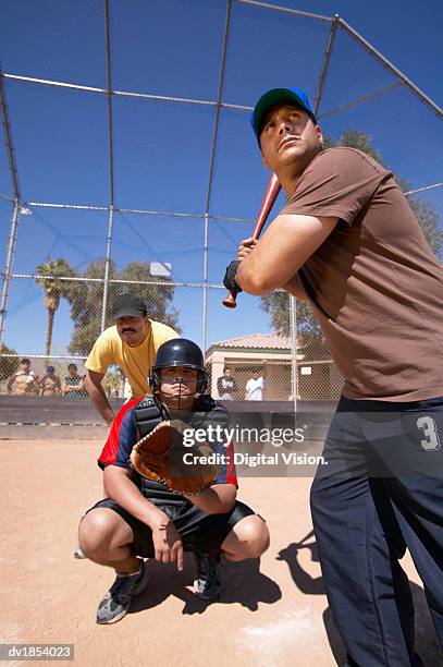 men playing baseball in a sports court - vangershandschoen stockfoto's en -beelden