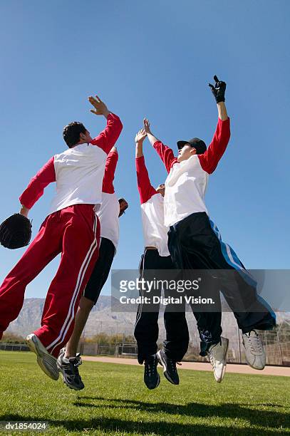 people in a baseball team jumping in a group giving each other a high five - baseball team 個照片及圖片檔