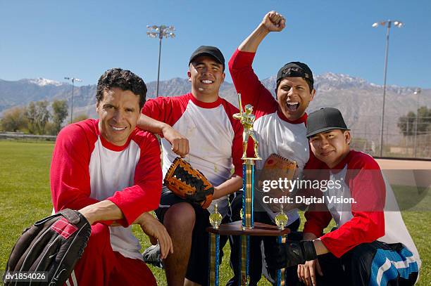 portrait of men in a winning baseball team with a trophy - winning baseball team stock pictures, royalty-free photos & images