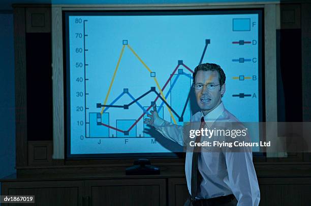 businessman explaining bar graph on a projection screen - image projetée photos et images de collection
