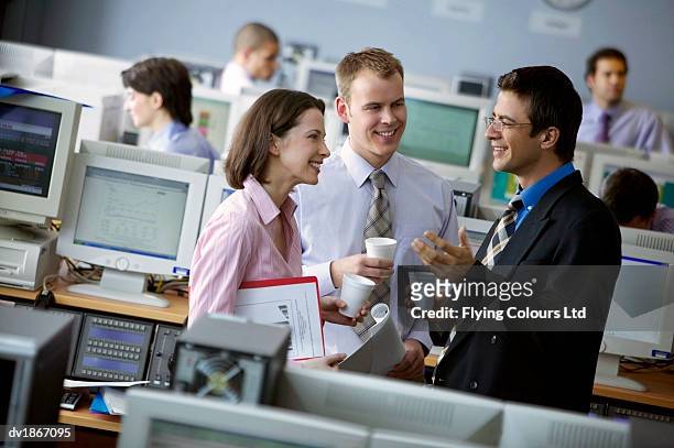 three colleagues stand talking during a coffee break in a call centre - centre de spectacles stockfoto's en -beelden
