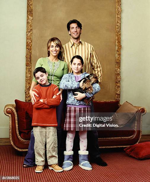 portrait of a family standing in an ornate living room - ornate house furniture stock-fotos und bilder